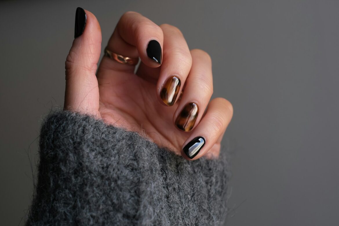 How to Care for Gel Nails: Keep Your Mani Healthy & Strong person wearing silver ring with black manicure