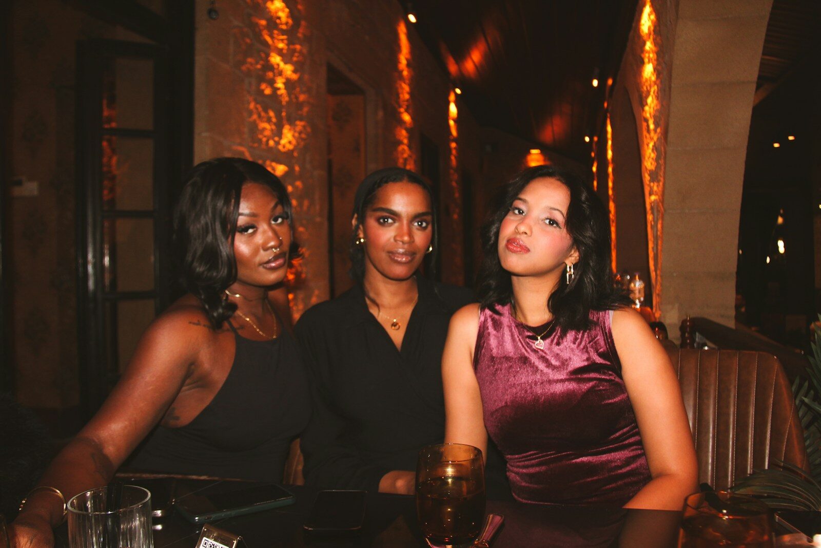 Three women posing at a table in a restaurant. girls night