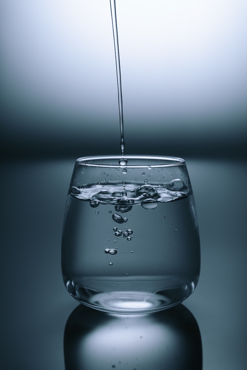 Hack: Cheap Alkaline Water clear drinking glass on gray surface